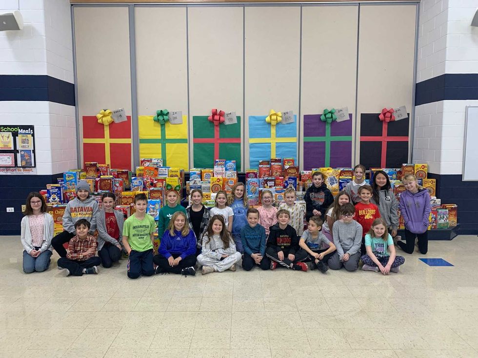 Students pose next to donated cereal boxes
