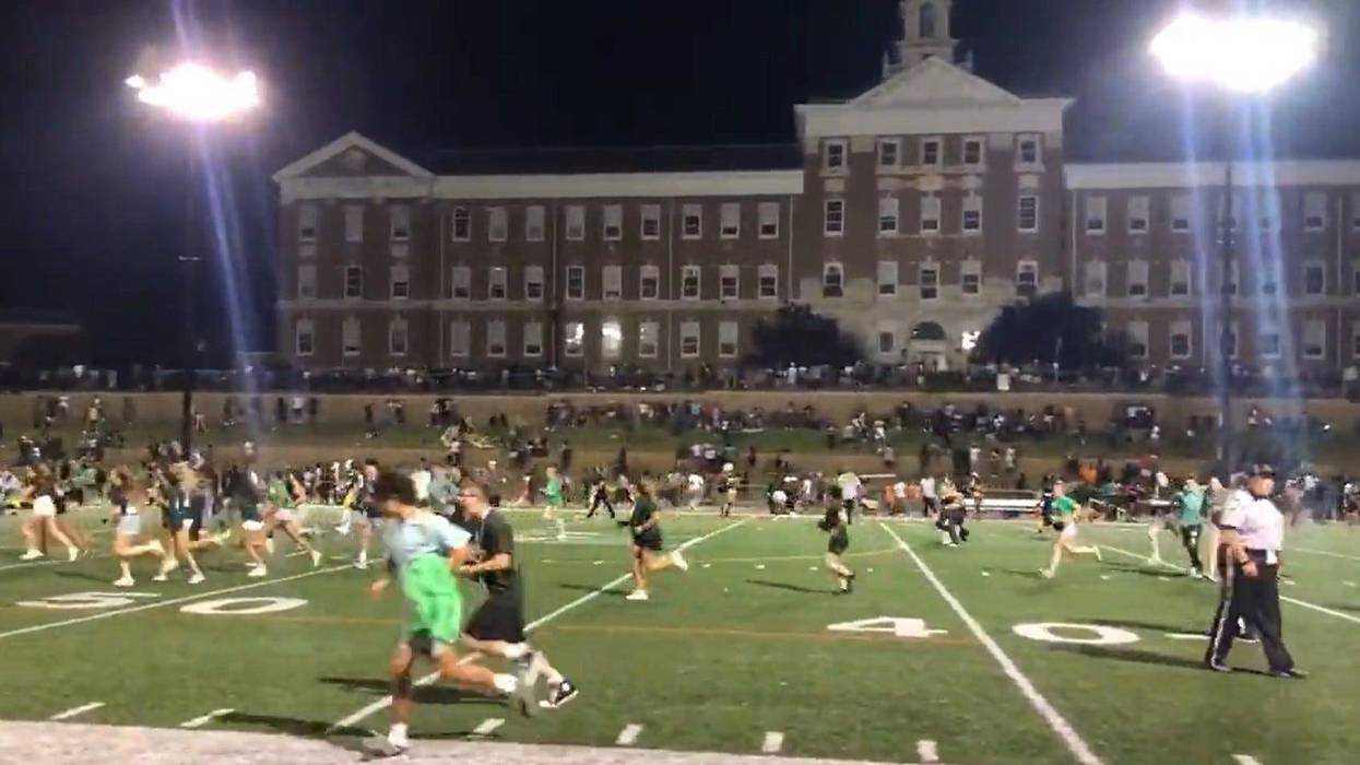 Students sprinting on the football field at Upper Darby High School after a report of shots fired during the school's game on Friday night. Police say the report was false, but there was a fight at the game that led to its cancellation.