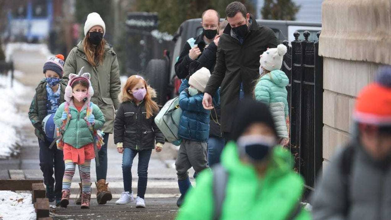 Students walk to A. N. Pritzker elementary school on January 12, 2022 in Chicago, Illinois. Students in Chicago public schools are returning to school today after classes were canceled for the past six days as the city sparred with the teacher's union over COVID-19 safety measures. (Photo by Scott Olson/Getty Images)