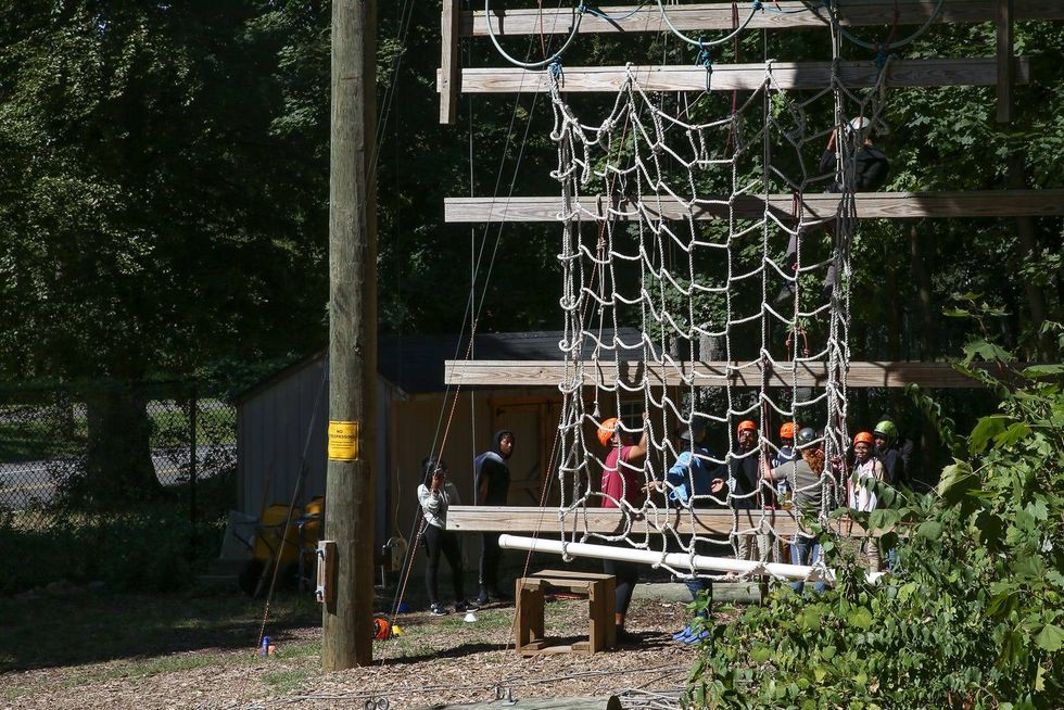 Students who are a part of the Philadelphia Outward Bound School participate in a ropes course at the Discovery Center in Fairmount Park.