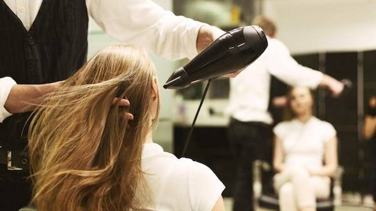Stylist blow-drying a woman’s hair