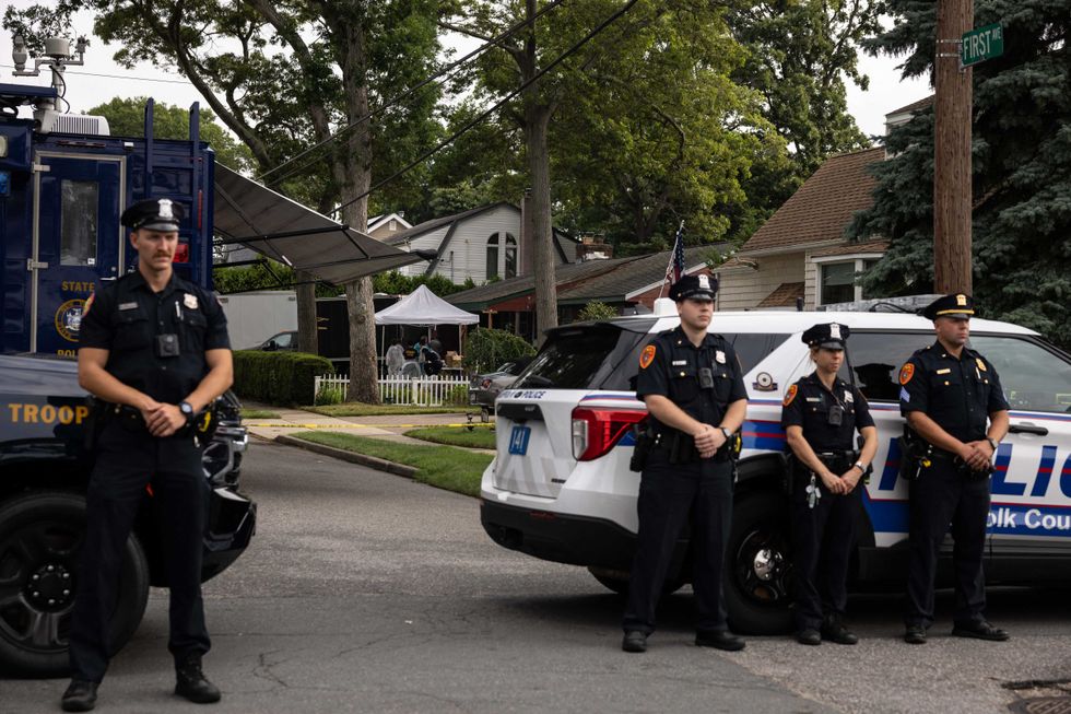 Suffolk County police officers stand guard as law enforcement searches the home of Gilgo Beach murders suspect Rex Heuermann in Massapequa Park on July 18, 2023