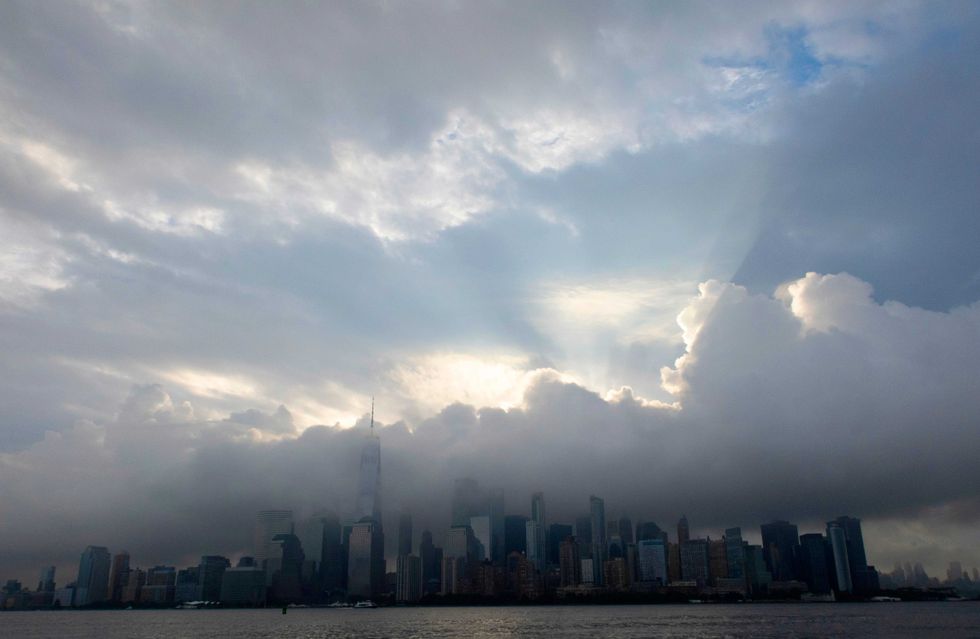 Sun shines through the clouds above Lower Manhattan on Sept. 11, 2023, as seen from Jersey City