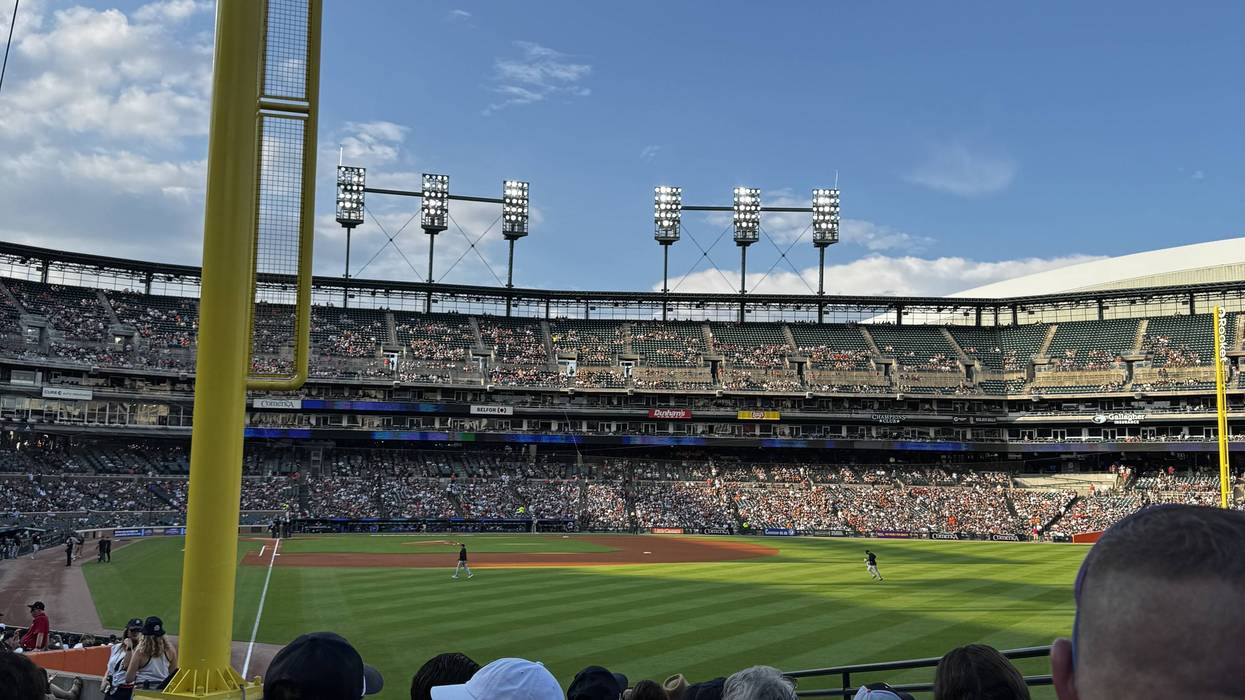 Sunny baseball game at Comerica Park, view from behind fans of the field, stadium, and foul pole.