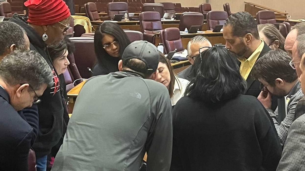 Supporters of Chicago's "alternate" budget plan huddle during a City Council committee hearing, December 17, 2025.