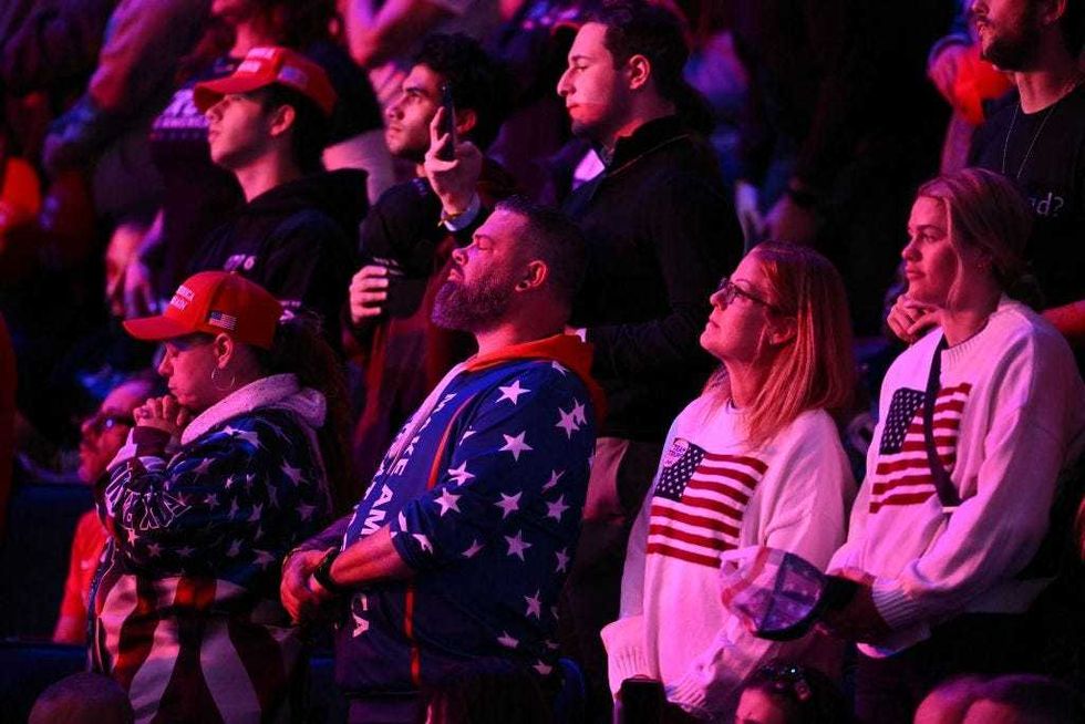 Supporters of former U.S. President and Republican presidential candidate Donald Trump pray as they wait for a campaign rally at Madison Square Garden in New York, Oct. 27, 2024.