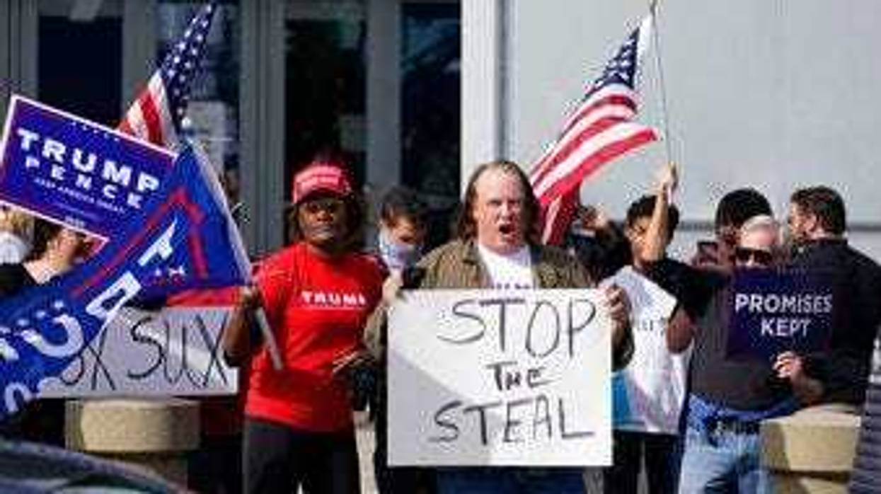 Supports of President Donald Trump holds signs during a demonstration outside the State Farm Arena where Fulton County has a voting counting operation, Thursday, Nov. 5, 2020, in Atlanta. (AP Photo/John Bazemore)