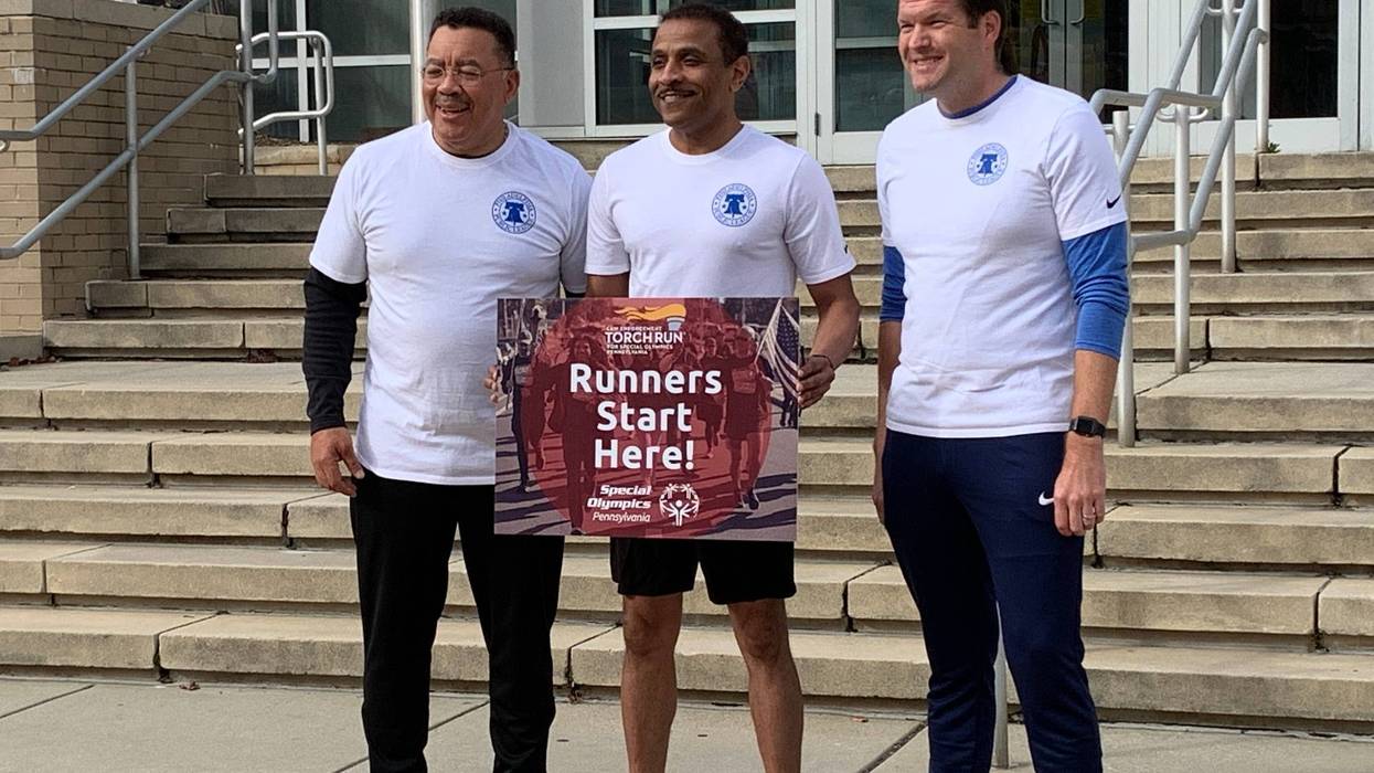 Supt. Tony Watlington (center) prepares to take the torch with School Safety Chief Kevin Bethel (left) and Dr. James Lynch, executive director of athletics.