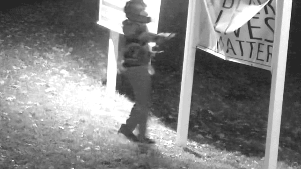 Surveillance images show a man in a motorcycle helmet damaging a "Black Lives Matter" sign outside a Unitarian church in Suffolk County in October