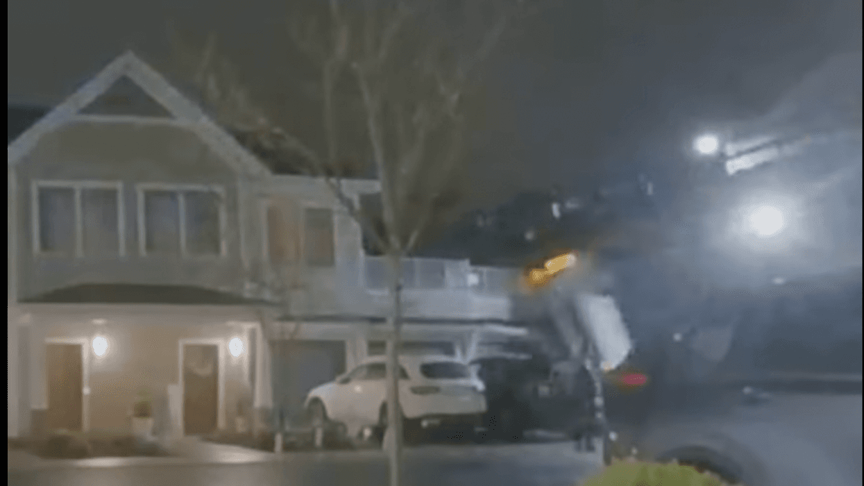 Surveillance video of car falling onto house from embankment