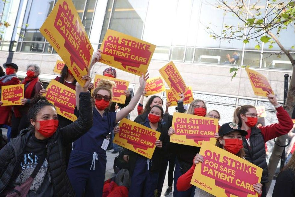 Sutter Health nurses and health care workers hold signs as they participate in a one day strike outside of the California Pacific Medical Center Van Ness Campus on April 18, 2022 in San Francisco, California.