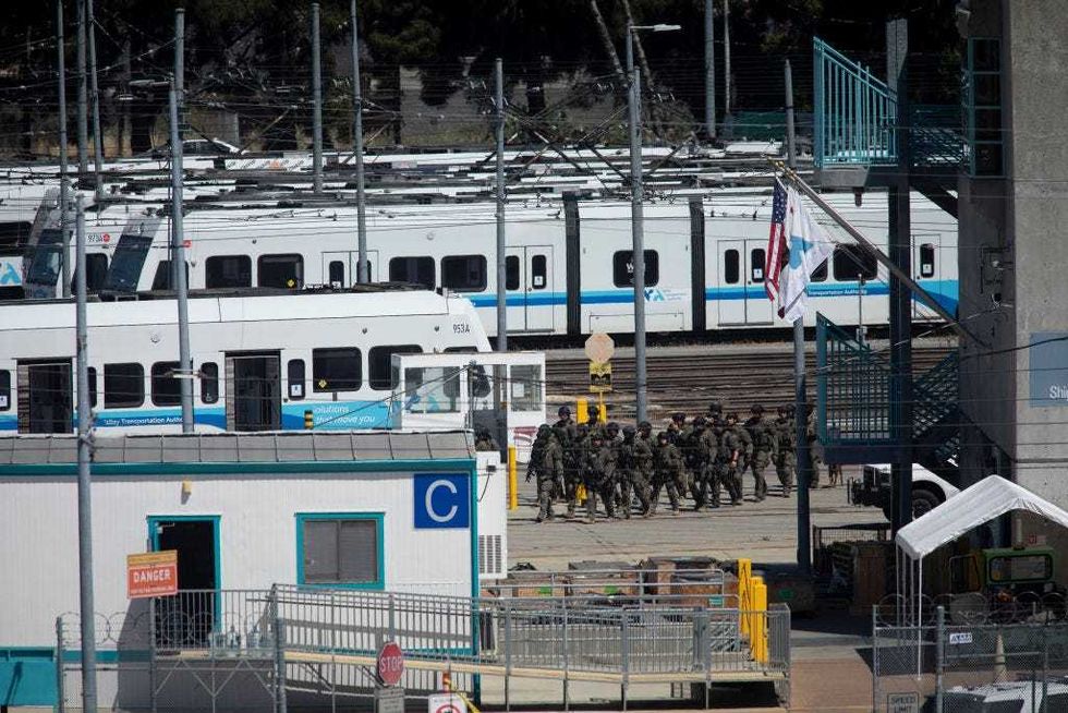 SWAT officers patrol the VTA light rail yard on Wednesday following a mass shooting that killed eight people, plus the gunman.