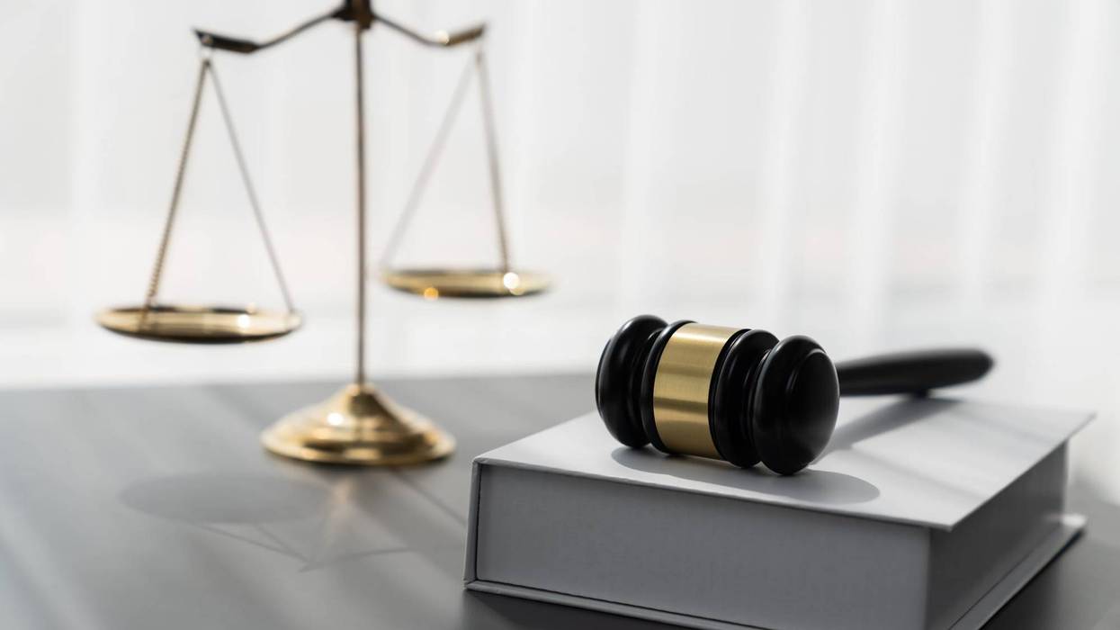 Symbolizing justice and legal authority, golden balanced scale and gavel on desk with law book in lawyer office background, reflecting concept of equality and fair judgment. equility