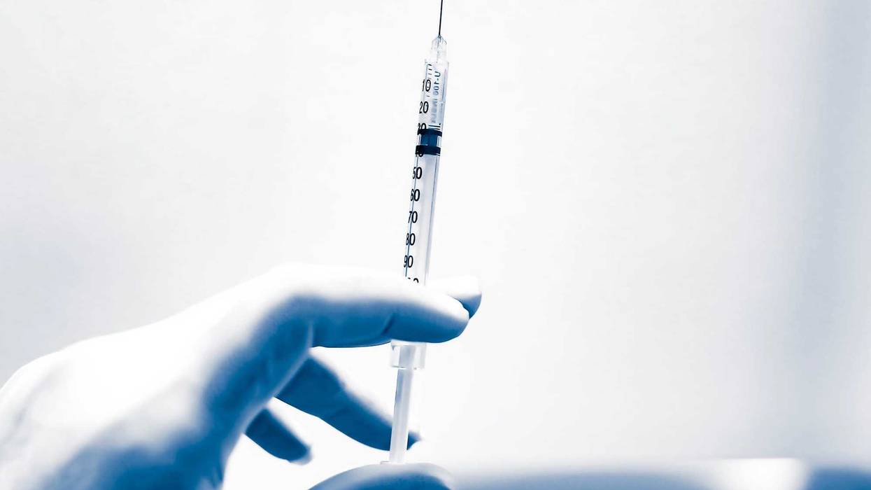 Syringe in gloved hand stock photo.