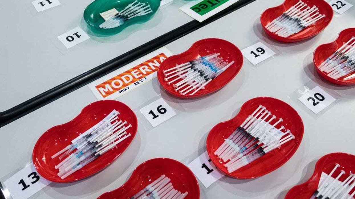 Syringes that contain the Pfizer/BioNTech vaccine (green) and the Moderna vaccine (red) against Covid-19.