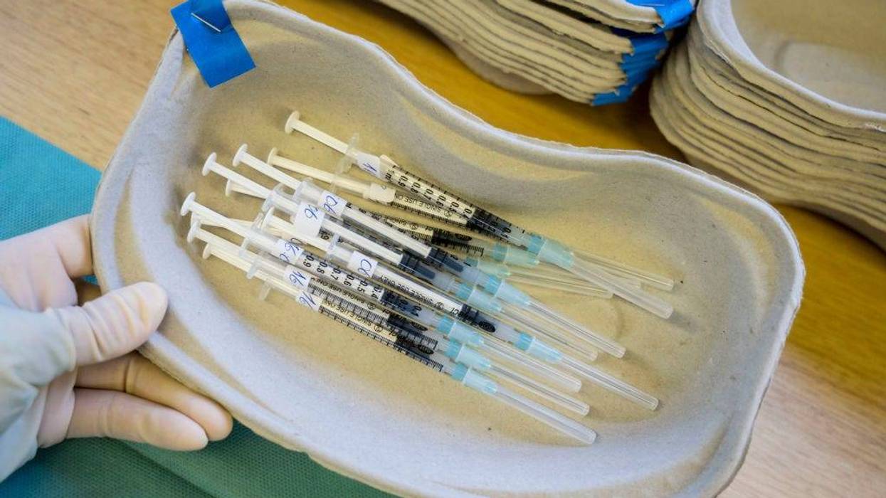 Tagreed Husain, Employee of the German Red Cross, prepares syringes with Moderna vaccine against Covid-19 in a mobile vaccination station in a street tram during the novel coronavirus pandemic on December 30, 2021 in Frankfurt, Germany.
