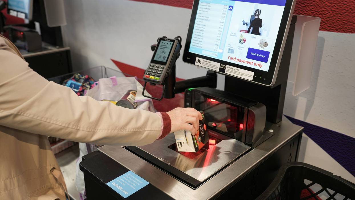 TARLETON, UNITED KINGDOM - JULY 22: A customer uses a self checkout terminal at the new Tarleton Aldi store on July 22, 2022 in Tarleton, United Kingdom. Aldi is the UK’s fifth largest supermarket chain and has 950 stores. The new Aldi store is the first in the Preston area.