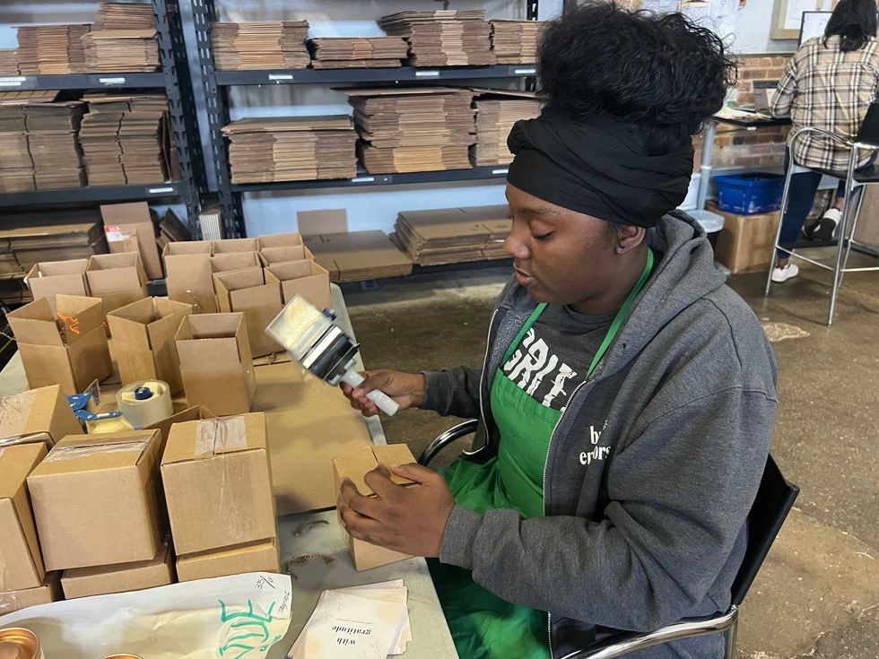 Tatiana Bolton packs up candles for an order at Bright Endeavors on the West Side. The program is one of many under the nonprofit New Moms.