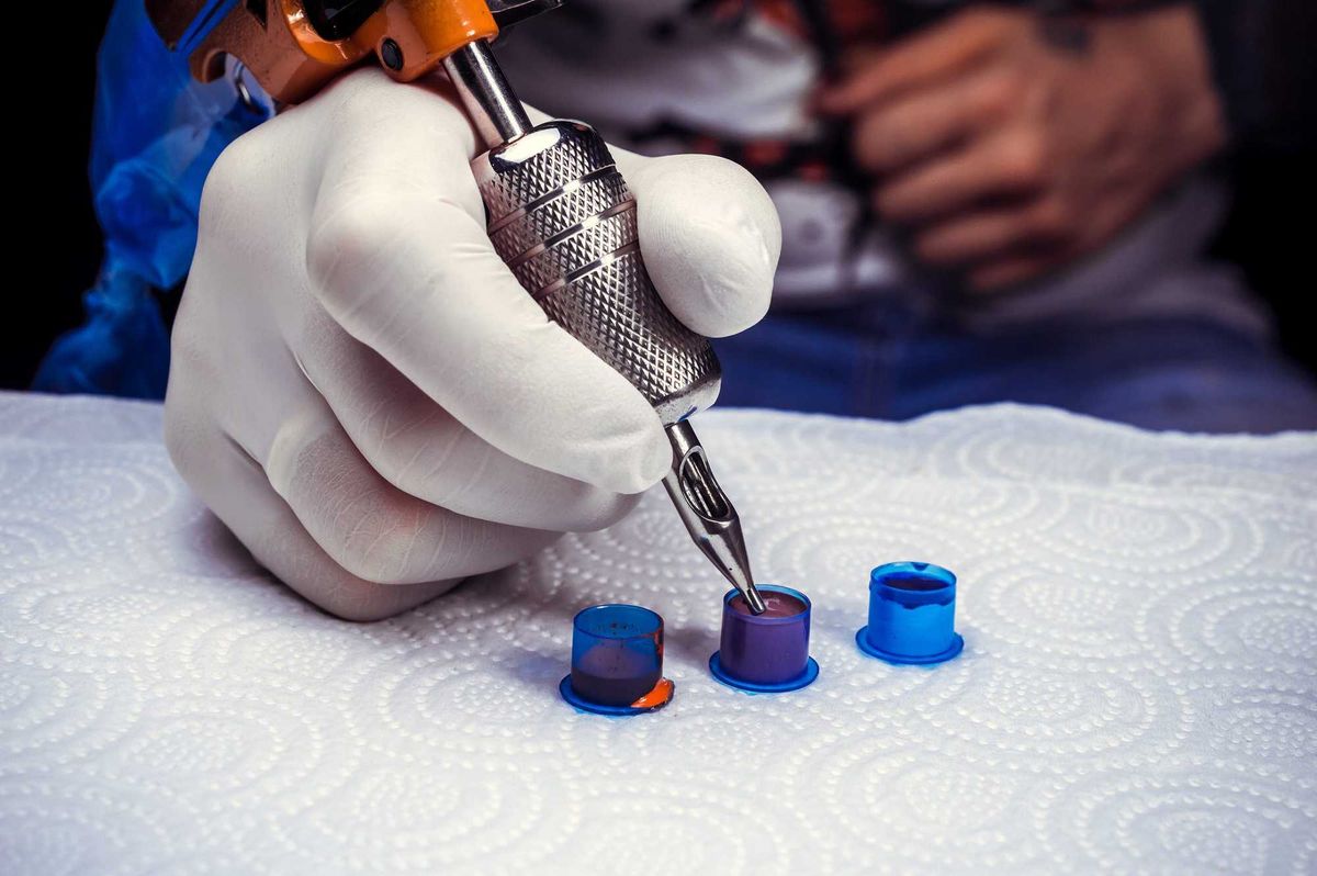 Tattoo artist prepares before giving a tattoo.