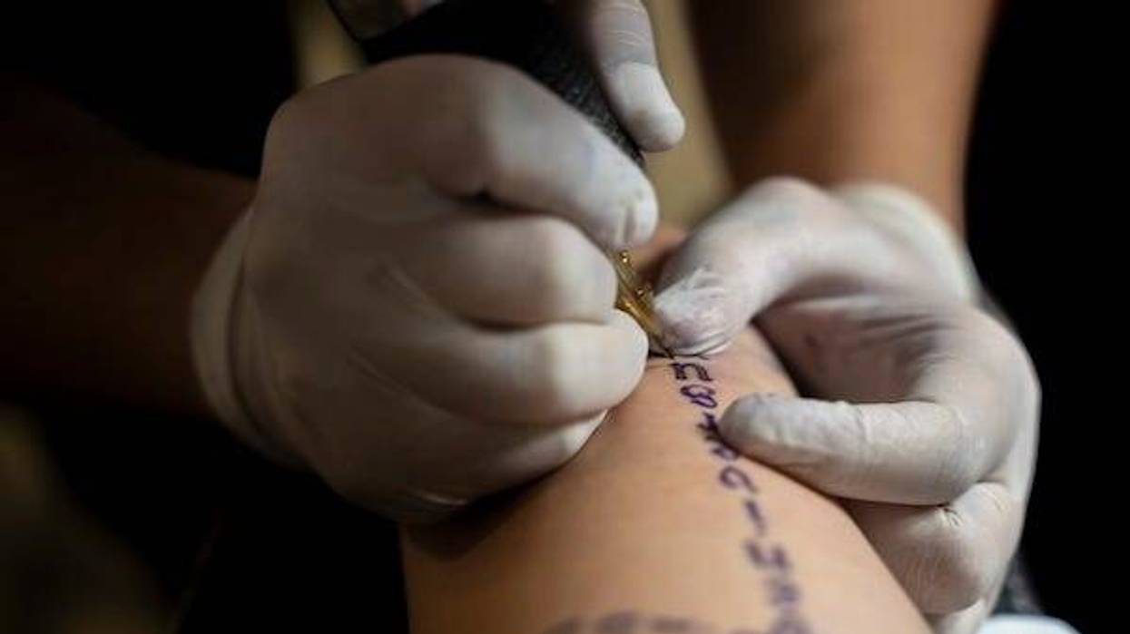 Tattoo artist tattooing a man’s arm