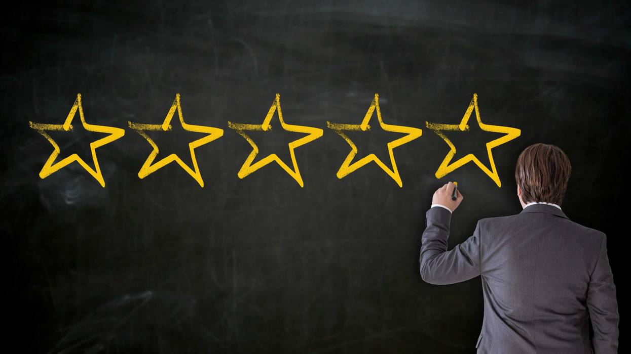 Teacher putting stars on a chalkboard.