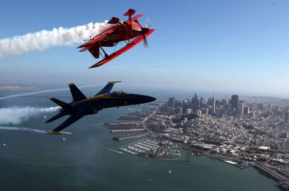 Team Oracle stunt pilot Sean Tucker (top) and a U.S. Navy Blue Angels F/A-18 Hornet piloted by U.S. Marine Corps Major Nathan Miller fly over the San Francisco Bay ahead of their Fleet Week performance October 8, 2009 in San Francisco, California.