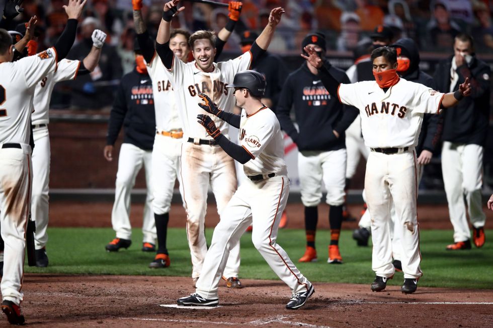 Teammates mobbing Mike Yastrzemski after his walk-off home run against the Padres
