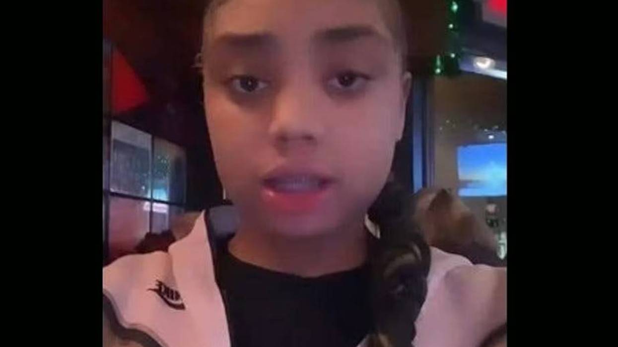 Teen girl with styled edges and a braid, wearing a light Nike jacket.