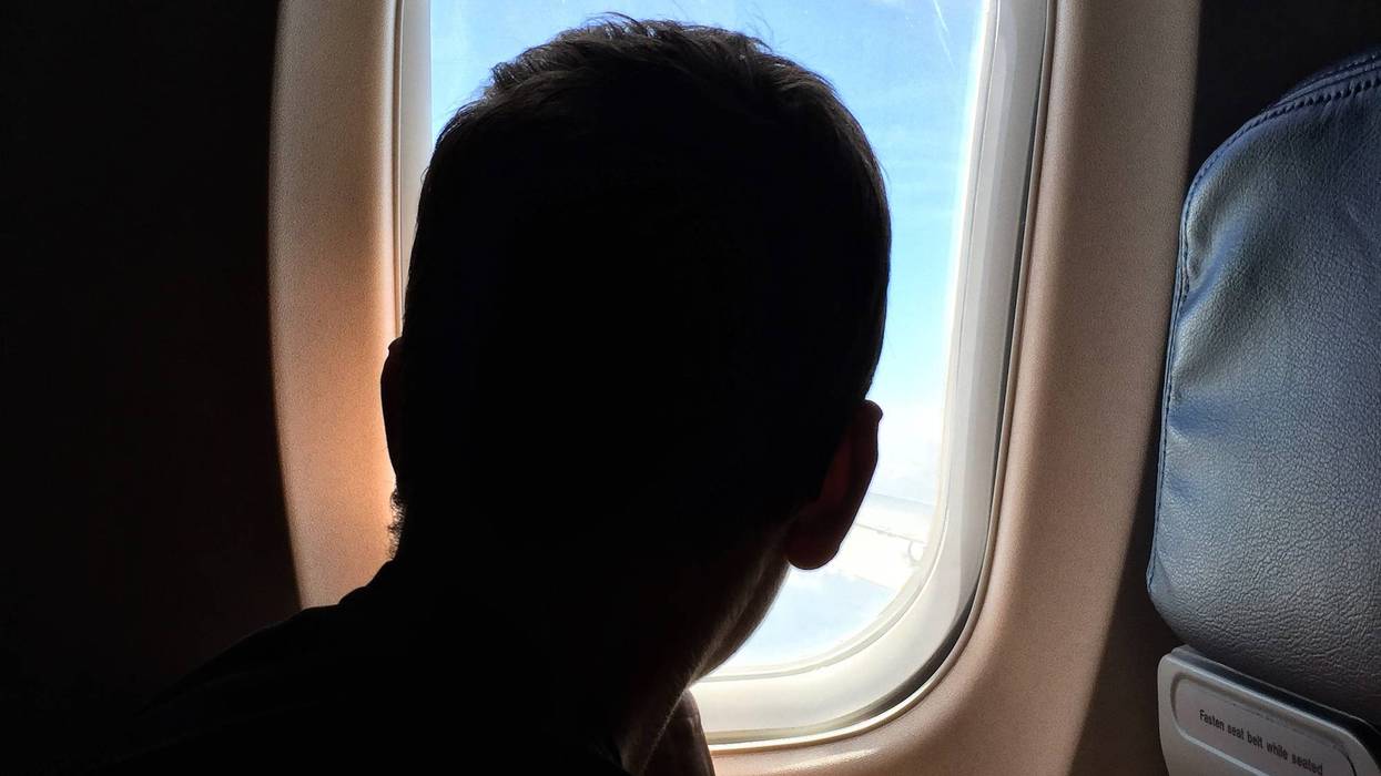Teen looking out of airplane window.