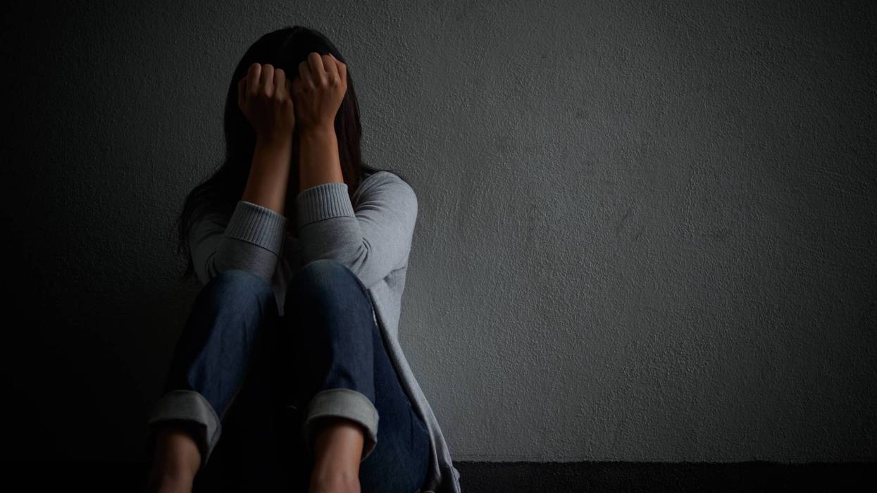 Teen sitting with her hands over her face