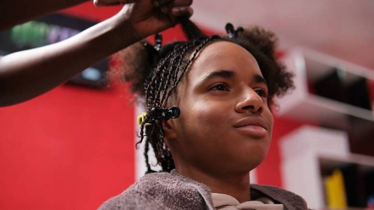 Teenage boy getting his hair braided