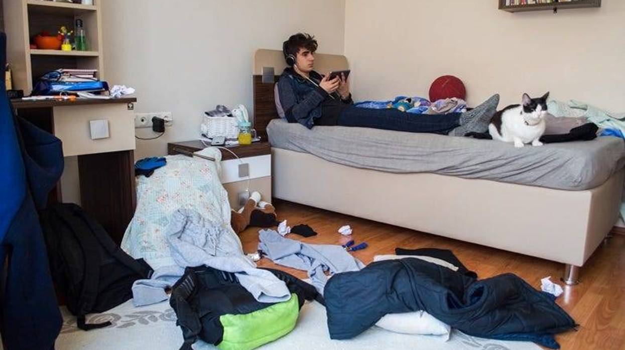teenager in messy bedroom
