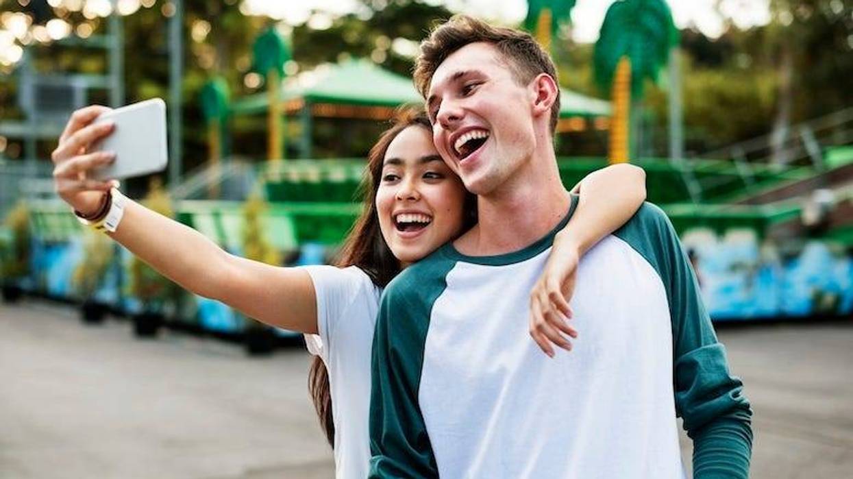 Teens posing for a selfie at an amusement park