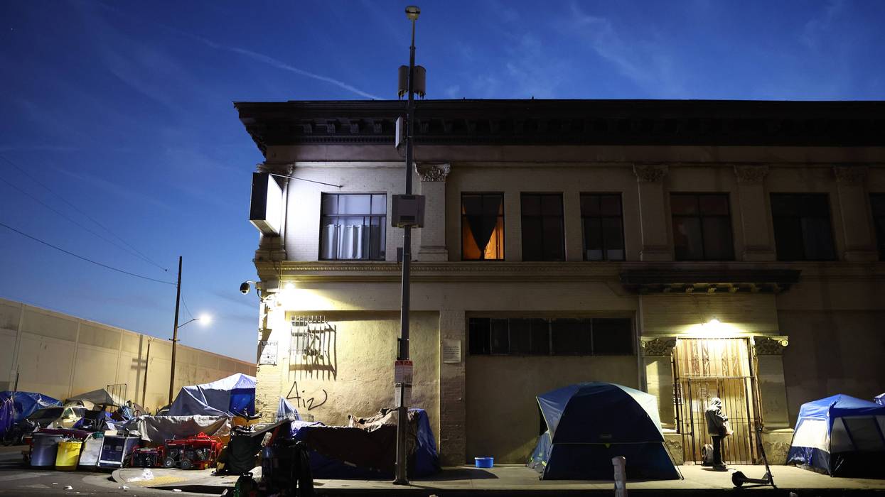 tents outside a dilapidated building at night