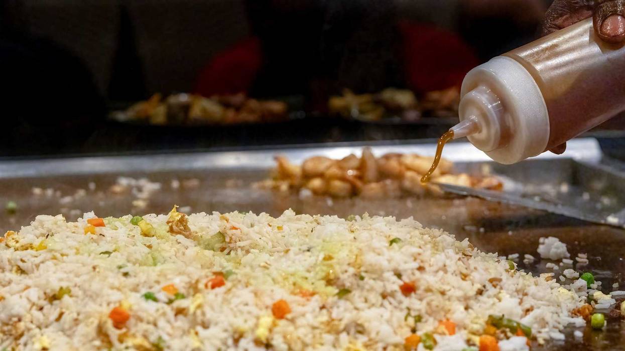Teppanyaki chef entertaining with spatulas and rice