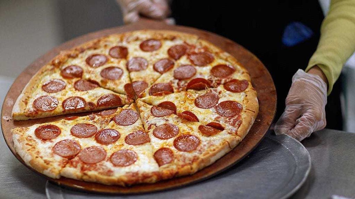 Terry Cheung prepares a pizza pie to be served to students at Everglades High School on November 18, 2011 in Miramar, Florida.