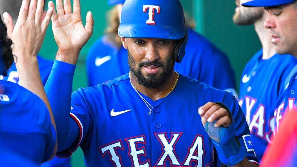 Texas Rangers' Marcus Semien is congratulated after scoring against the Kansas City Royals