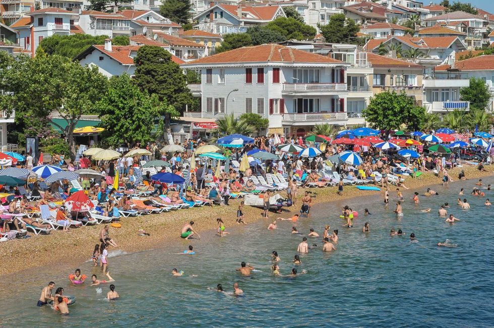 The beach at Knalada, seen from the deck of a ferry boat from Istanbul, that is about to stop over at the island to offload day trippers from the city. Knalada is one of the Prince Islands, a small archipelago on the Sea of Marmara. It is located a short boat ride from Istanbul city center and is a popular destination for those wishing to escape from the overcrowded megapolis, especially during the summer months.