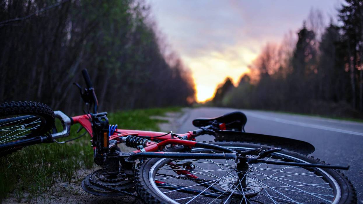The bike lies on the roadway of the asphalt road in the lem