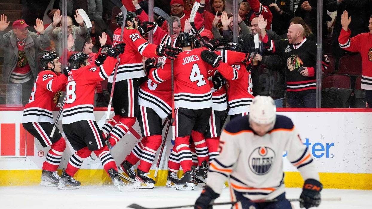 The Blackhawks celebrate after winger Alex DeBrincat scored a game-winning goal against the Oilers in overtime.