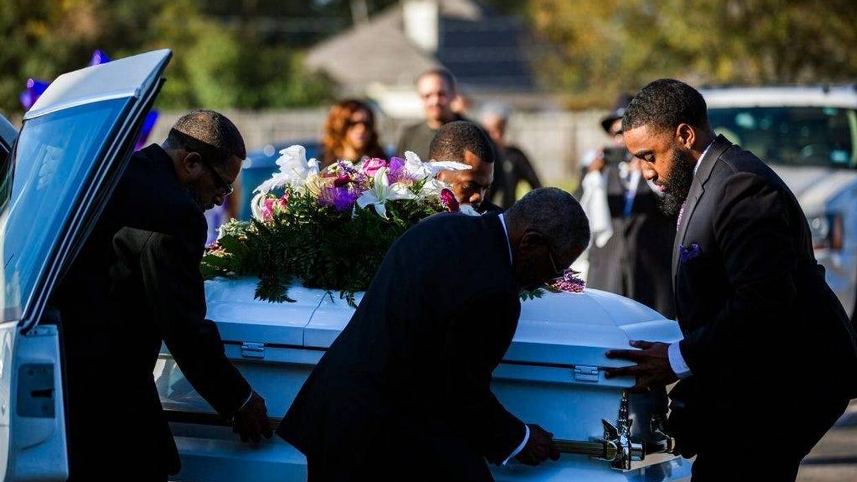 The casket of Jazmine Barnes is removed from the funeral hearse