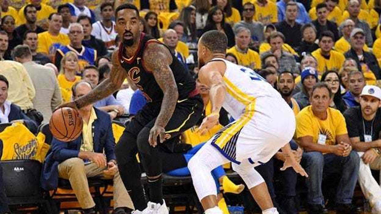 The Cavaliers' J.R. Smith dribbles while being defended by the Warriors' Stephen Curry.