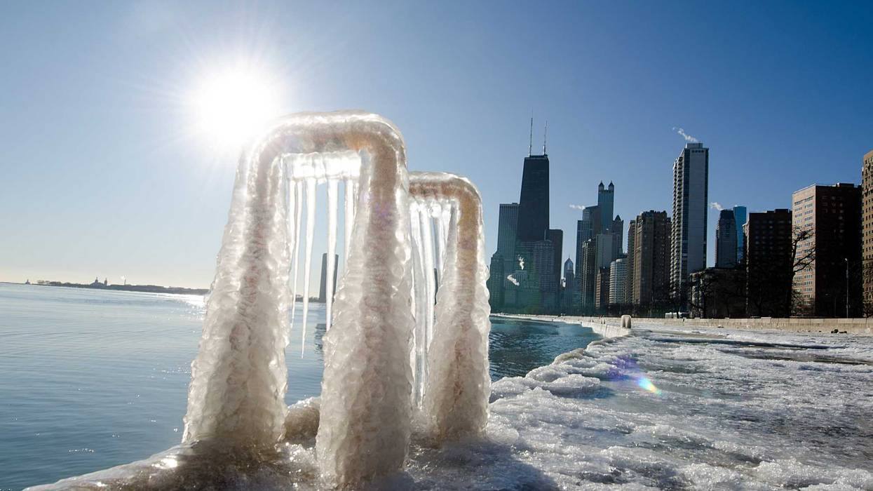 The Chicago skyline is reflected in a frozen lake