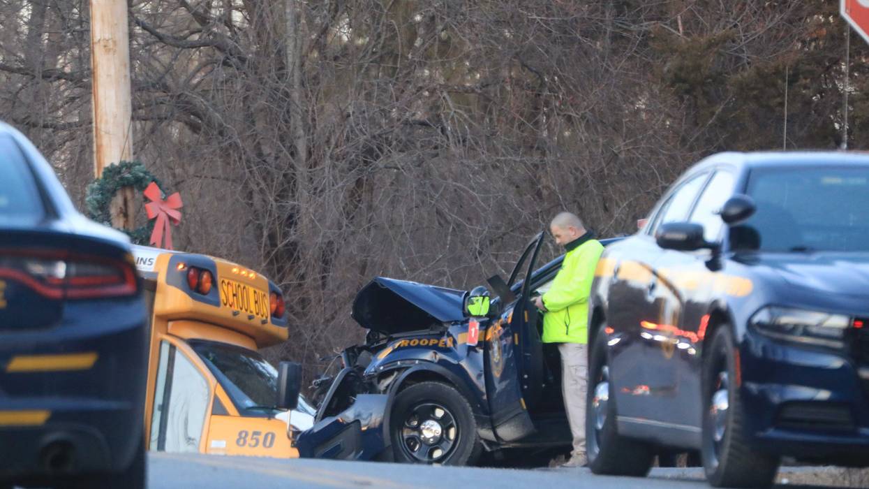 The crash between the school bus and the police car left one dead and four injured.