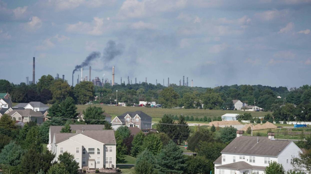 The Delaware City Refinery emits black smoke into the air in the distance over a residential neighborhood in New Castle, Delaware.