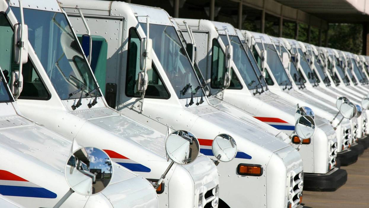 the front ends of USPS delivery trucks, lined up