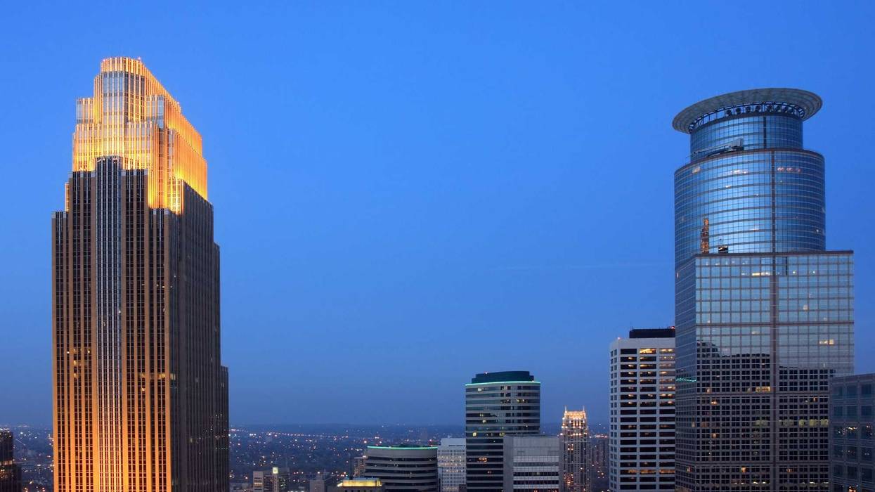 The golden-lit Wells Fargo Center (Left) dominates the Minneapolis skyline as the third tallest building behind the IDS Center and the Capella Tower (Right).