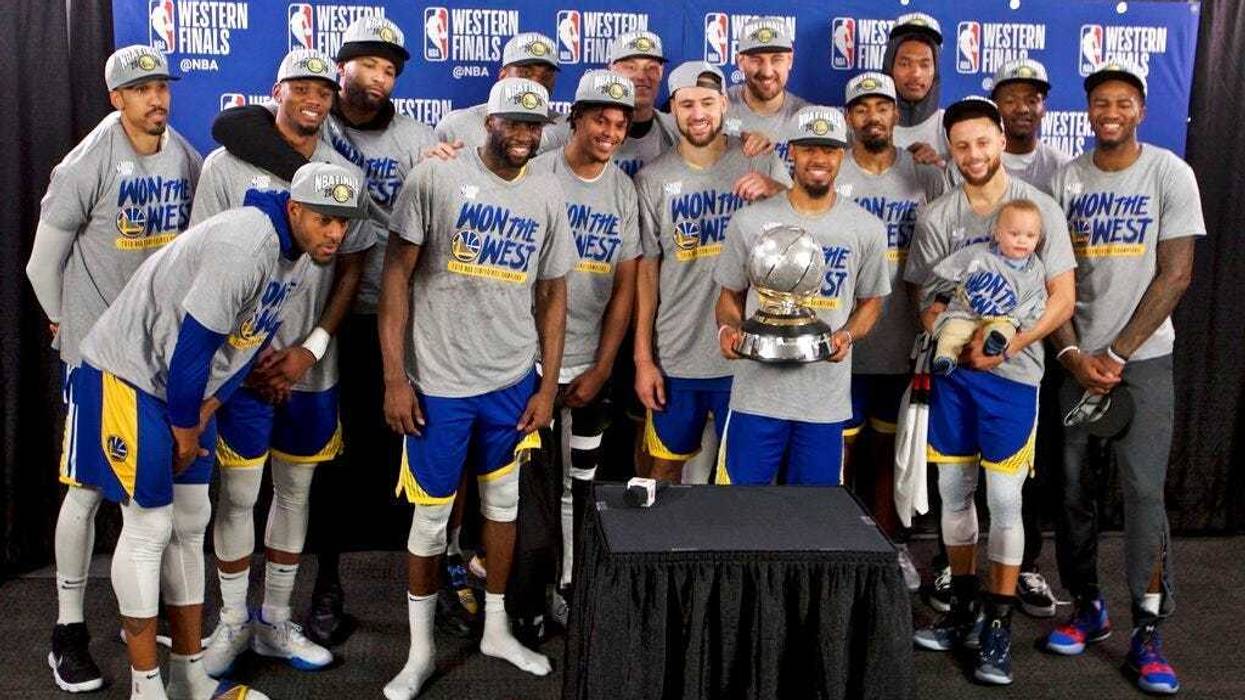 The Golden State Warriors players pose with the Western Conference Championship trophy