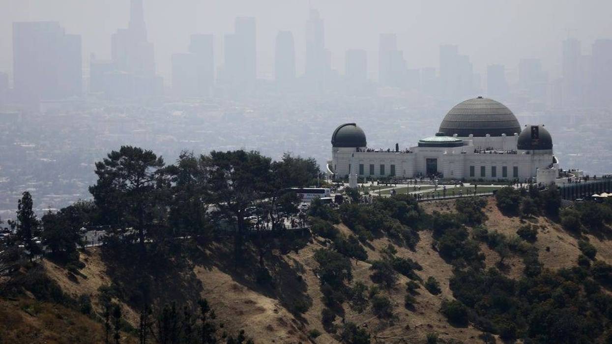 The Griffith Observatory stands (R) in front of downtown Los Angeles on July 5, 2019 in Los Angeles, California. Air quality was predicted to reach the 'unhealthy' range in the Los Angeles metropolitan area today by the South Coast Air Quality Management District following last night's fireworks. Fireworks are often launched illegally in Los Angeles. July 4th and July 5th are normally some of the worst days of the year for air quality as fireworks launch fine-particle pollution into the air. (Photo by Mario Tama/Getty Images)