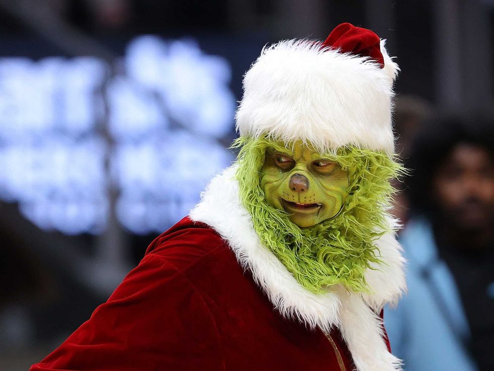 The Grinch character is seen tossing out shirts during the first half between the Atlanta Hawks and the Orlando Magic at State Farm Arena on December 22, 2021 in Atlanta, Georgia. NOTE TO USER: User expressly acknowledges and agrees that, by downloading and or using this photograph, User is consenting to the terms and conditions of the Getty Images License Agreement. (Photo by Kevin C. Cox/Getty Images)